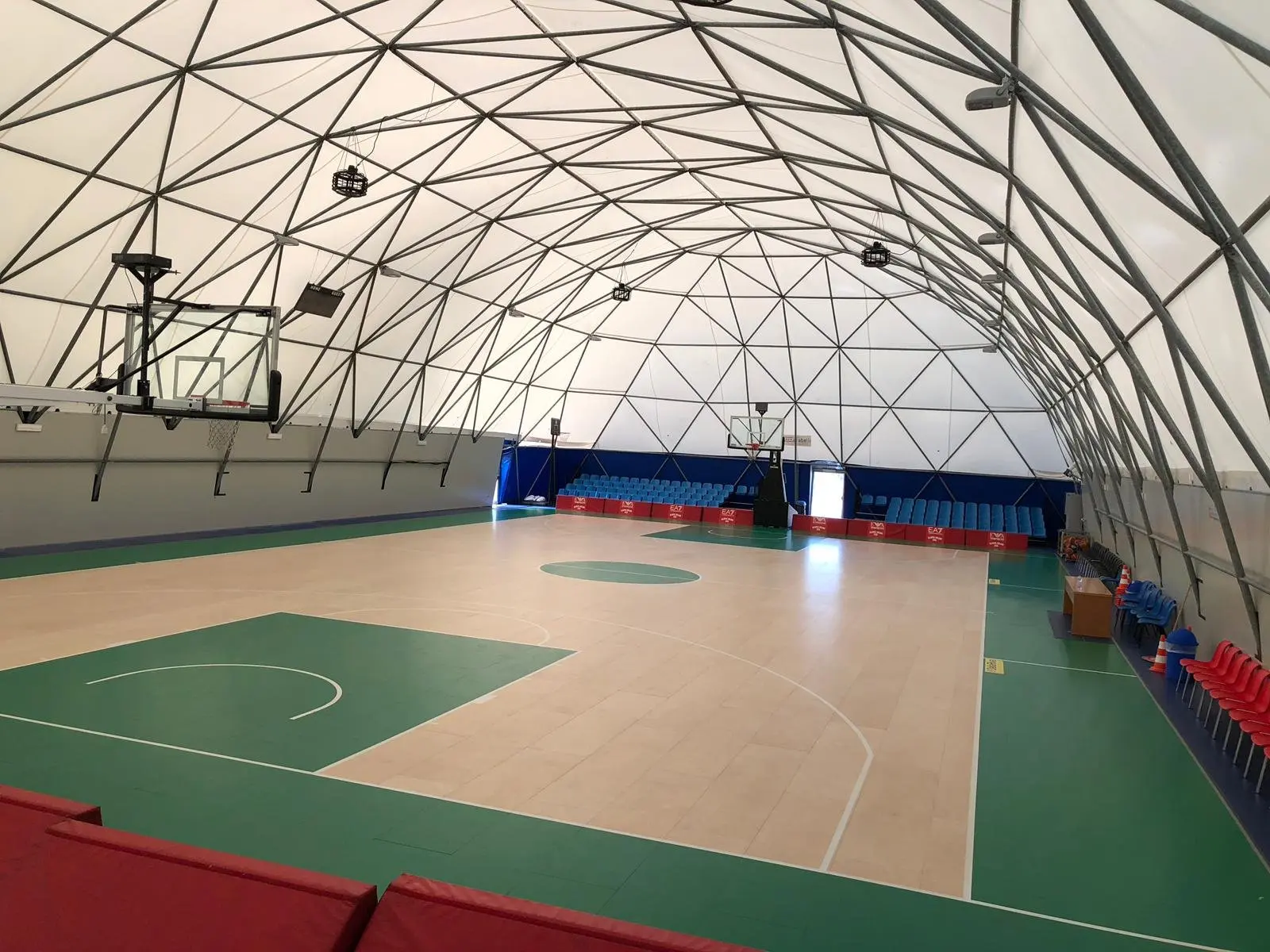 Court, seating and clear-span roof inside a geodesic hall